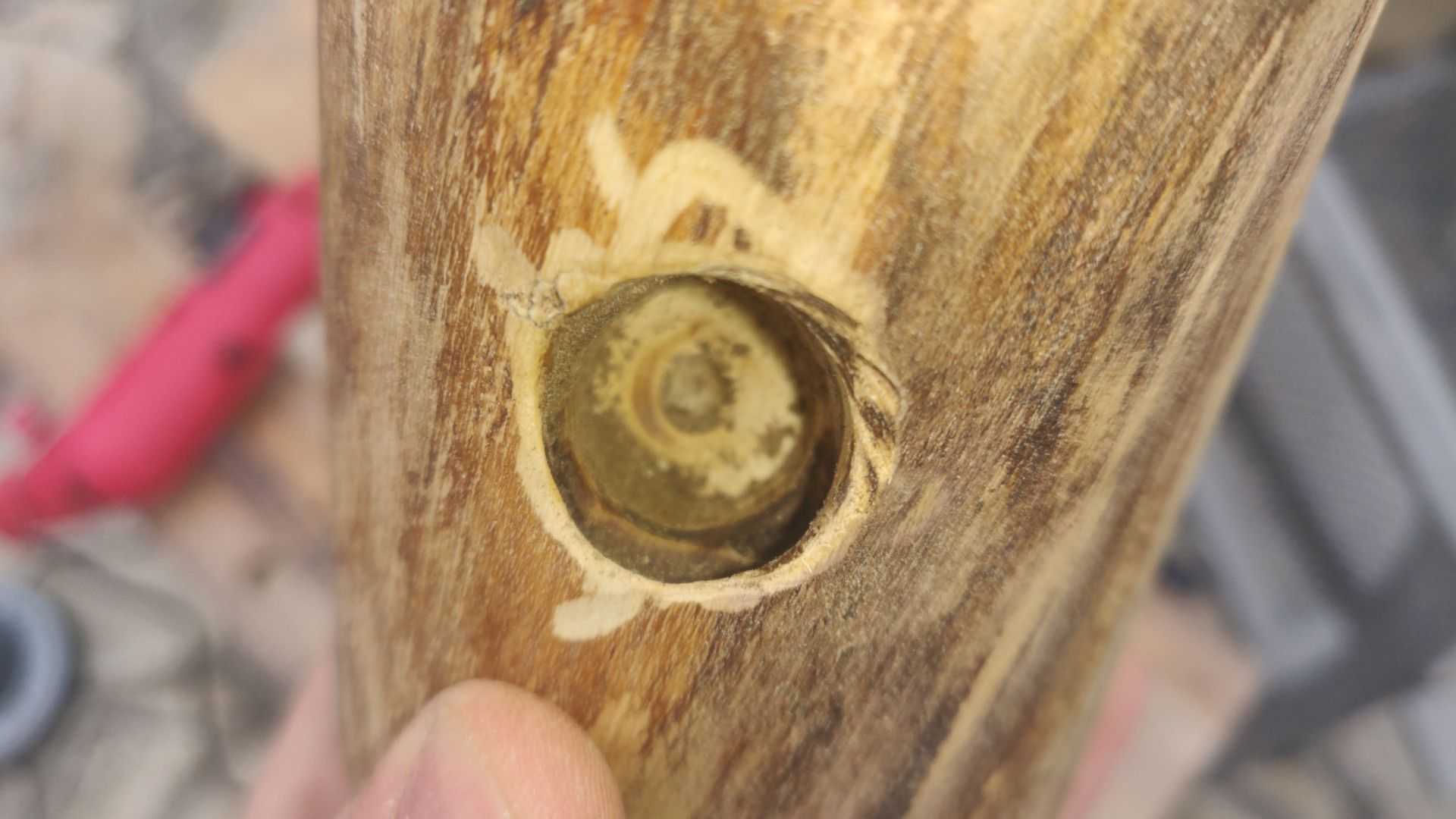 A hole drilled at an angle into the wooden candleholder.